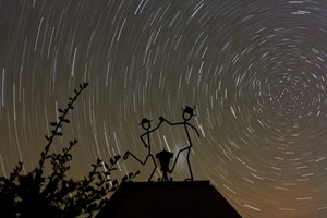 Sternstrichspuren über Hakos, NamibiaDie Figuren über dem Eingang zur Hakos Farm in Namibia tanzen vor dem Sternenhimmel. Am Knie der rechten Figur erkennt man den Schein der Kleinen Magellanschen Wolke, einer Satellitengalaxie unserer Milchstraße.Digitale APS-C Spiegelreflexkamera, WeitwinkelobjektivBrennweite 28 mm – Blende 4,5 – ISO 800Belichtungszeit 32 min01.06.2005, Hakos Farm, Namibia